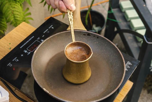 Brewing Arabic coffee with cardamom on a pot on top of a pan, which pan is on an induction plate. We had to manage somehow.