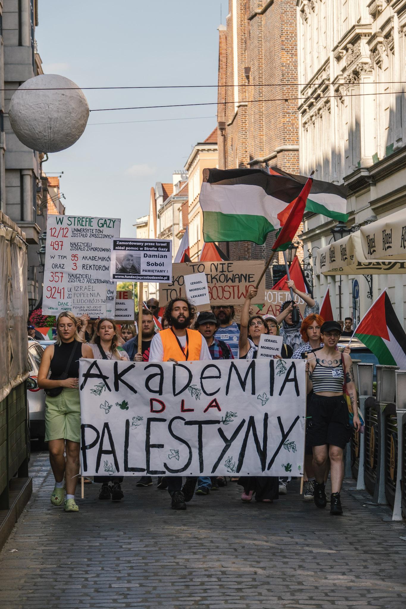 Protesters marching through a narrow street in the Old Town. The shot is facing the protesters.