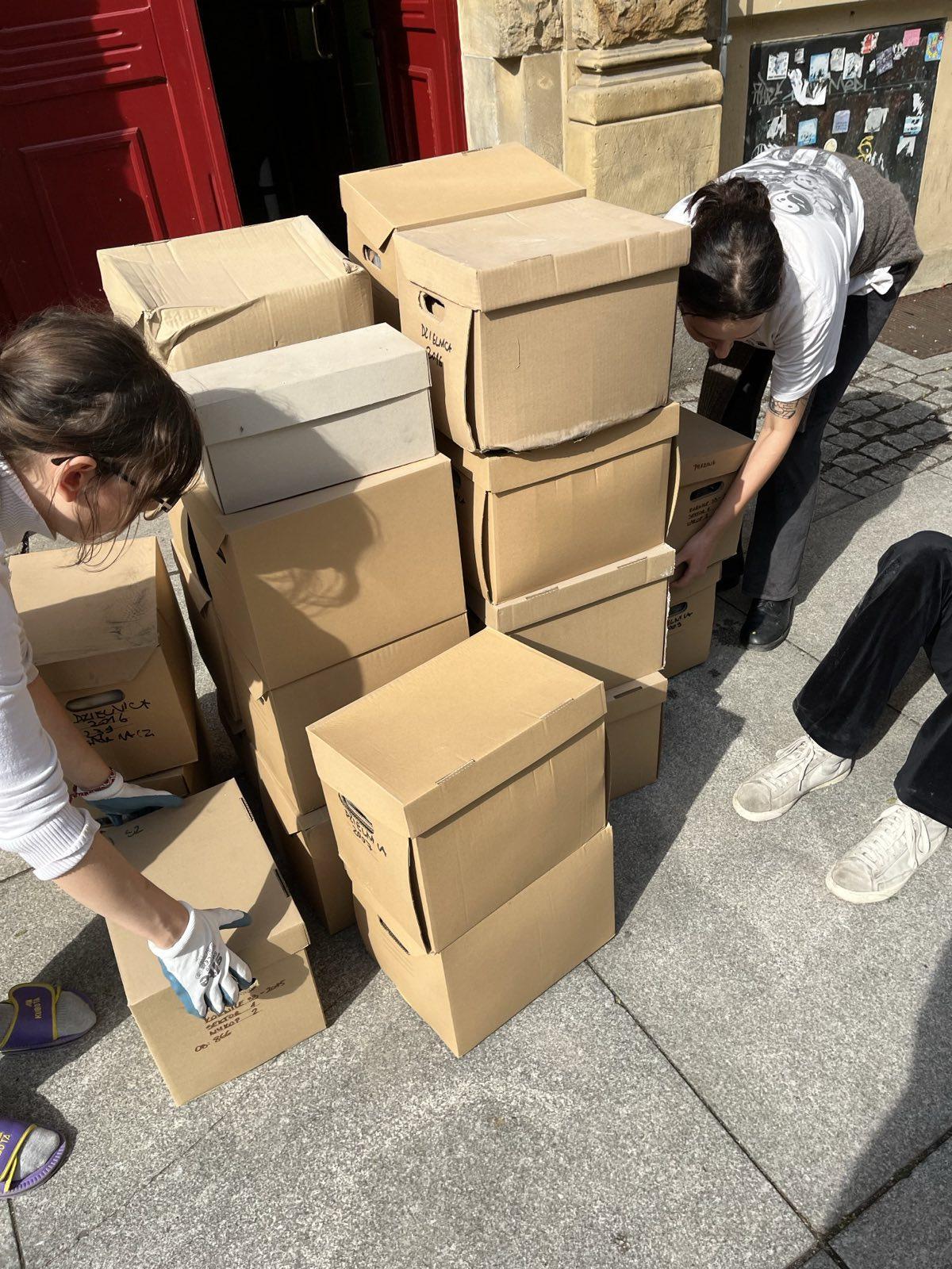 Students with cardboard boxes brought up out of a cellar at Szewska Street.